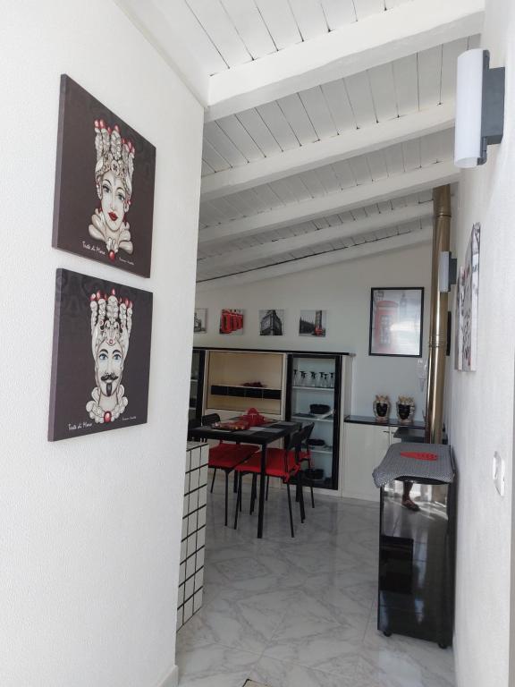 a kitchen and dining room with a dog art on the wall at Mamà Apartment in Augusta