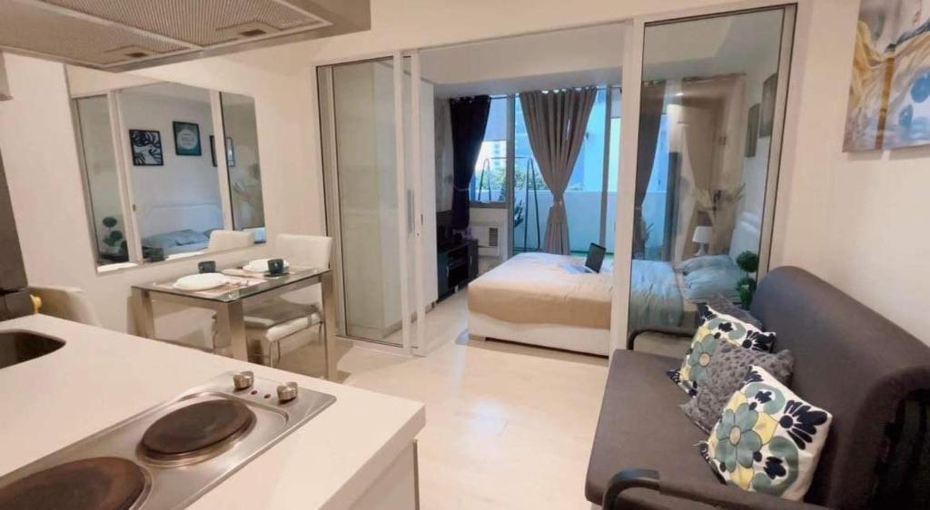 ein Wohnzimmer mit einer Küche und ein Schlafzimmer mit einem Bett in der Unterkunft Azure Condo Hotel Near Manila Ninoy Aquino International Airport in Manila