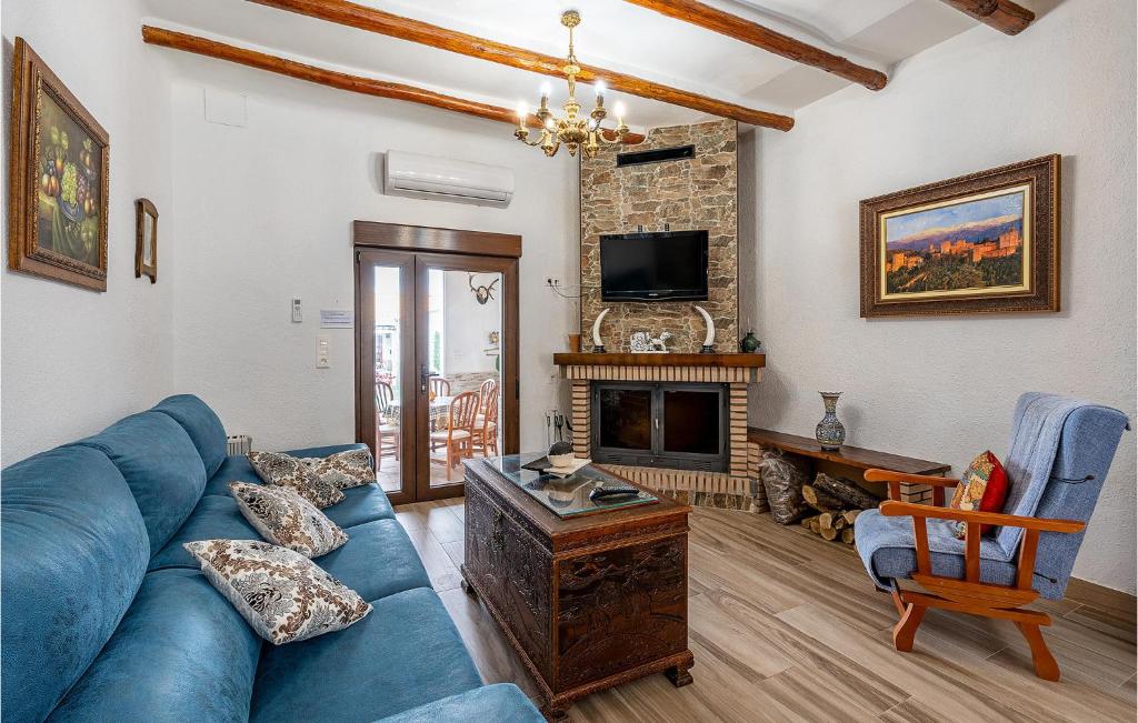 - un salon avec un canapé bleu et une cheminée dans l'établissement 5 Bedroom Awesome Home In Trasmulas, Granada, à Trasmulas
