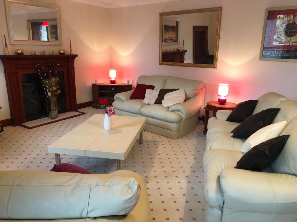 a living room with two couches and a table at Executive Serviced apartments 2 in Forfar
