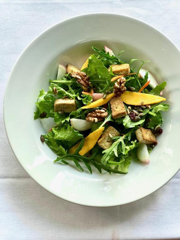 a salad in a white bowl on a table at Firefly Estate Bequia in Crescent Beach
