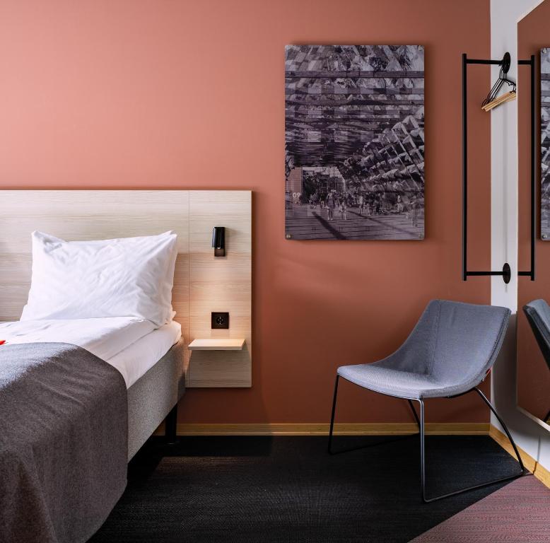 a bedroom with a bed and a chair at Citybox Oslo in Oslo