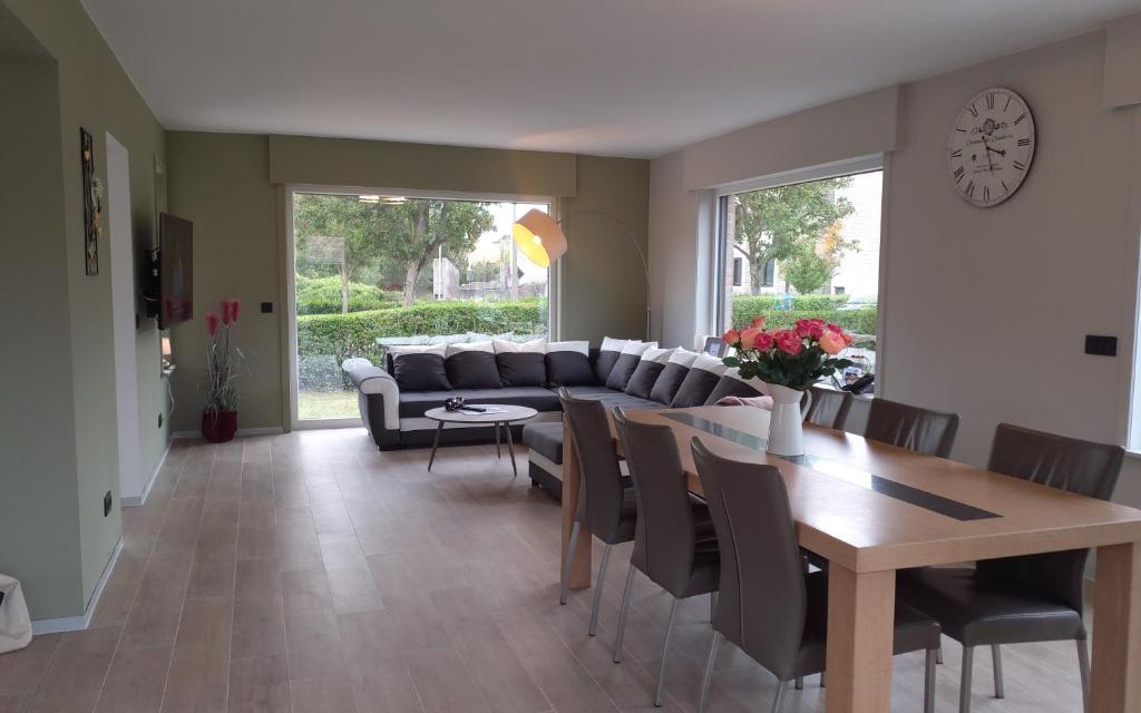 a living room with a couch and a table and chairs at Villa 't Zonneroosje in Nieuwpoort