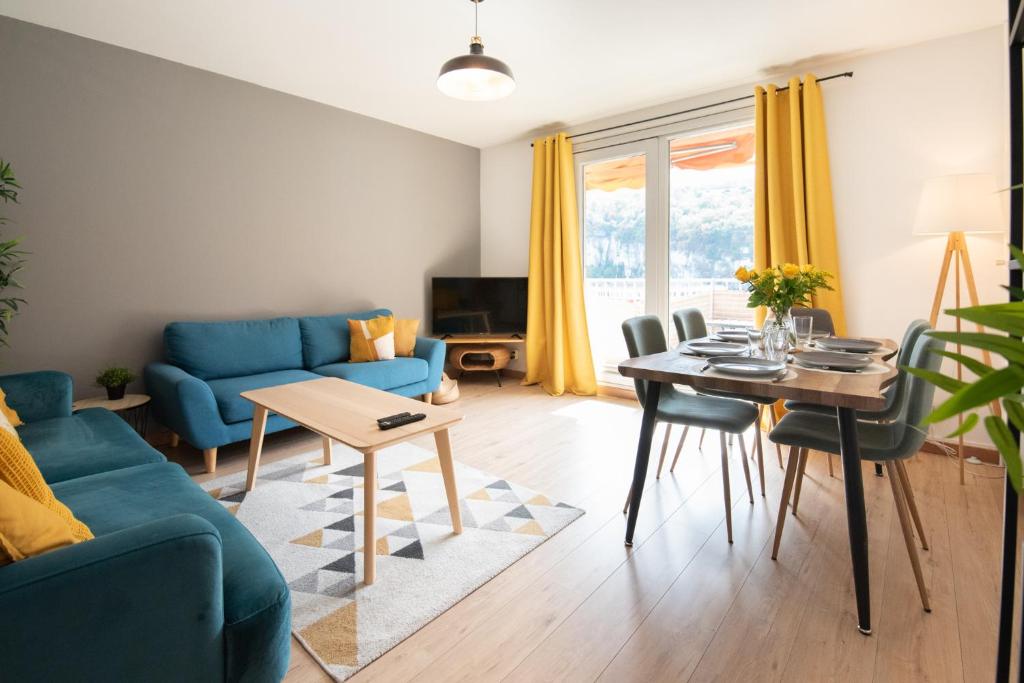 een woonkamer met een blauwe bank en een tafel bij Appartement du Vercors - 3 Bedrooms Parking Free Netflix in Fontaine