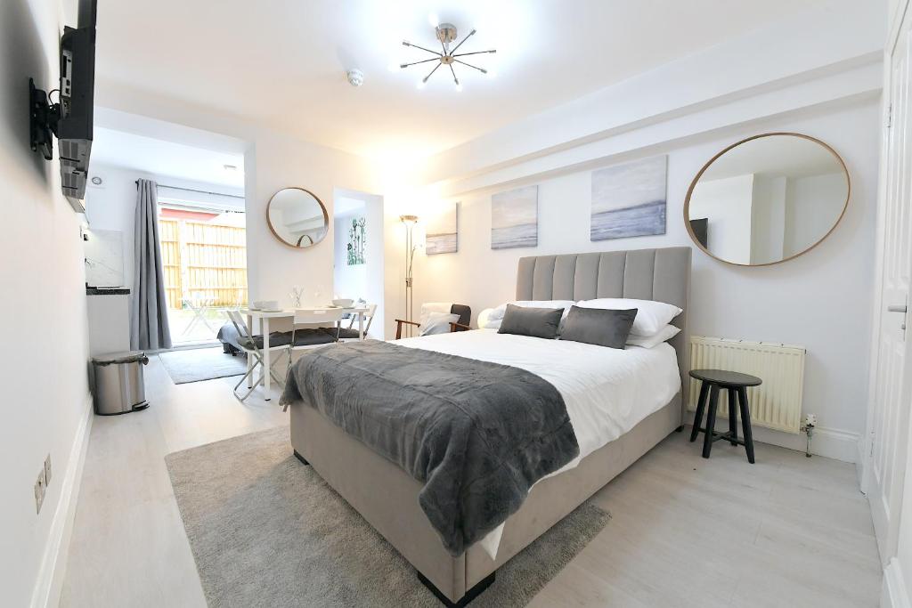 - une chambre avec un lit, une table et un miroir dans l'établissement London Studios Very Close to Central Line Underground Shepherds Bush and Westfield Newly Refurbished, à Londres