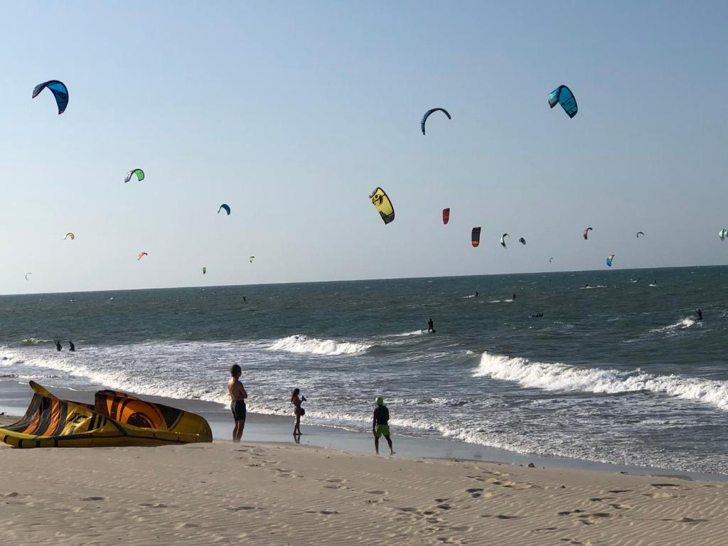 een groep mensen op het strand die vliegeren bij Diversão, férias, casa na praia de cumbuco. in Caucaia