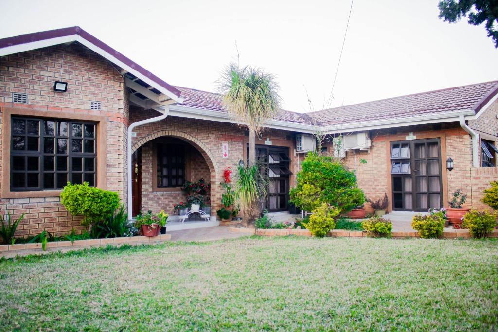 a brick house with a palm tree in the yard at Pitikwe Hill Guesthouse in Lobatse