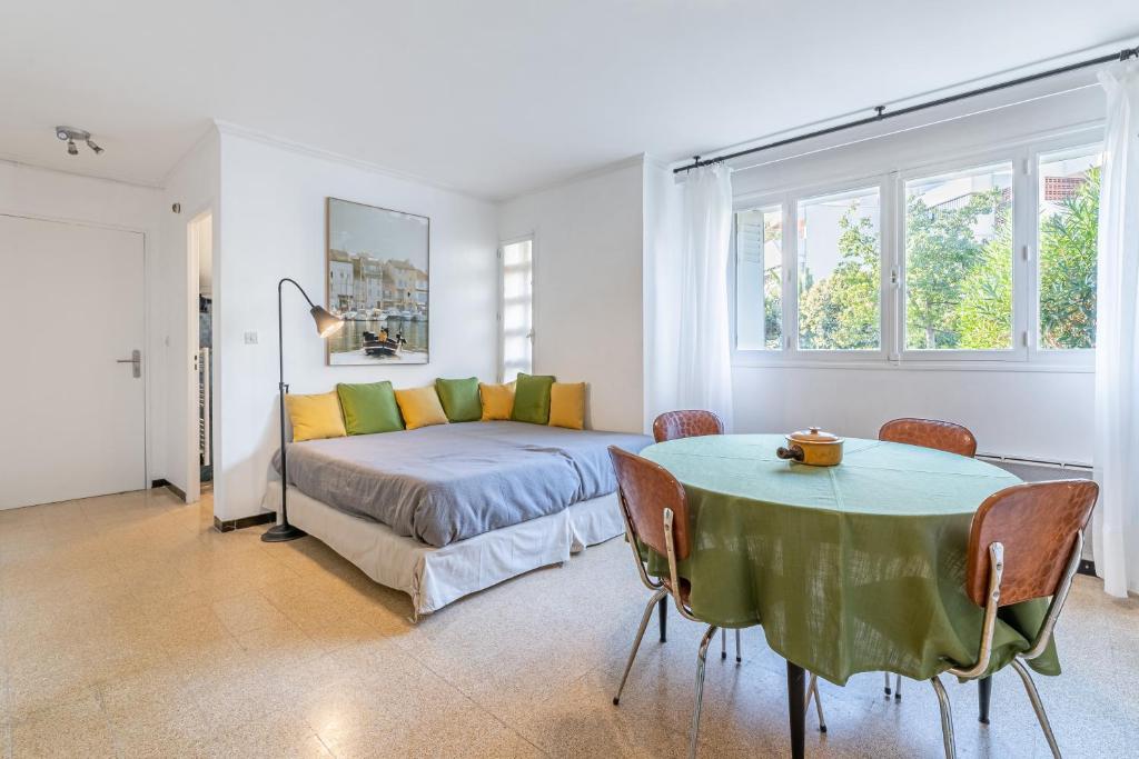 Schlafzimmer mit einem Bett und einem Tisch mit Stühlen in der Unterkunft Le Marignan- Studio plein centre in Cassis