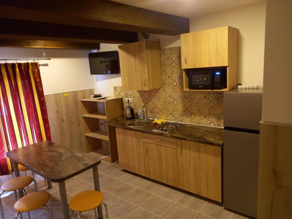 una pequeña cocina con mesa y nevera en ROOMS FOR RENT, en Panevėžys