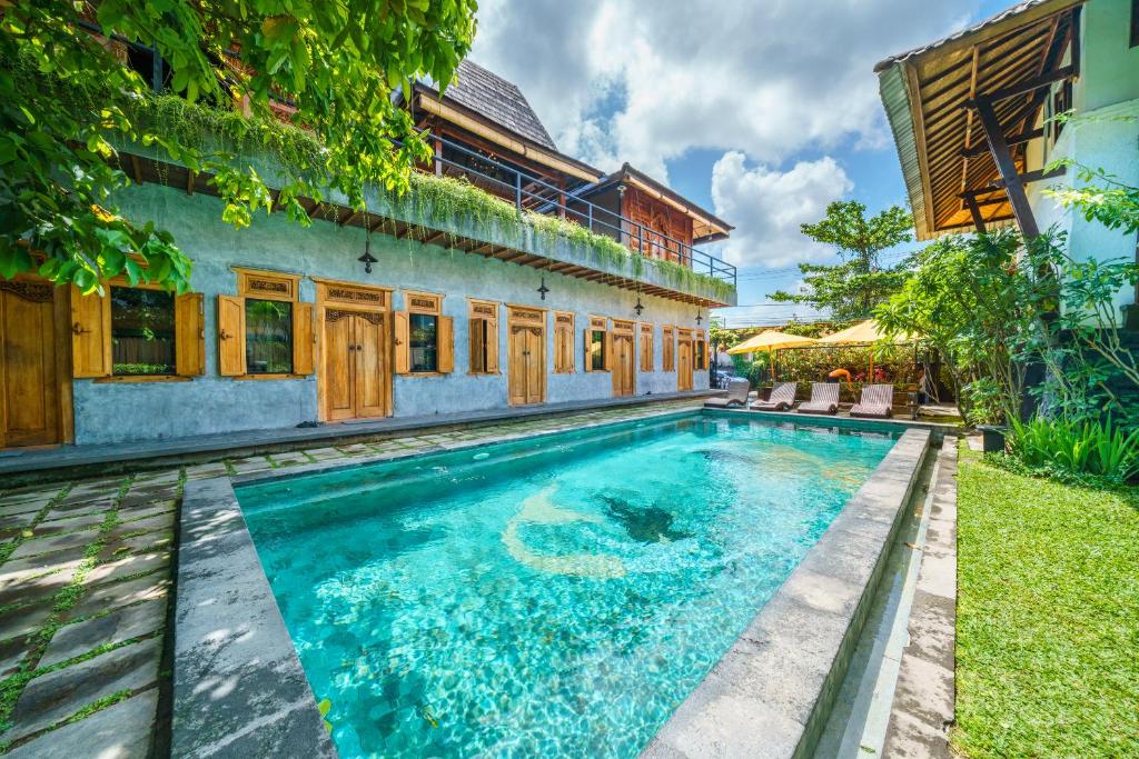 a swimming pool in the backyard of a house at Black Pearl Hostel in Canggu