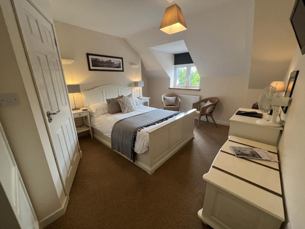 a small bedroom with a bed and a window at The Foxham in Chippenham