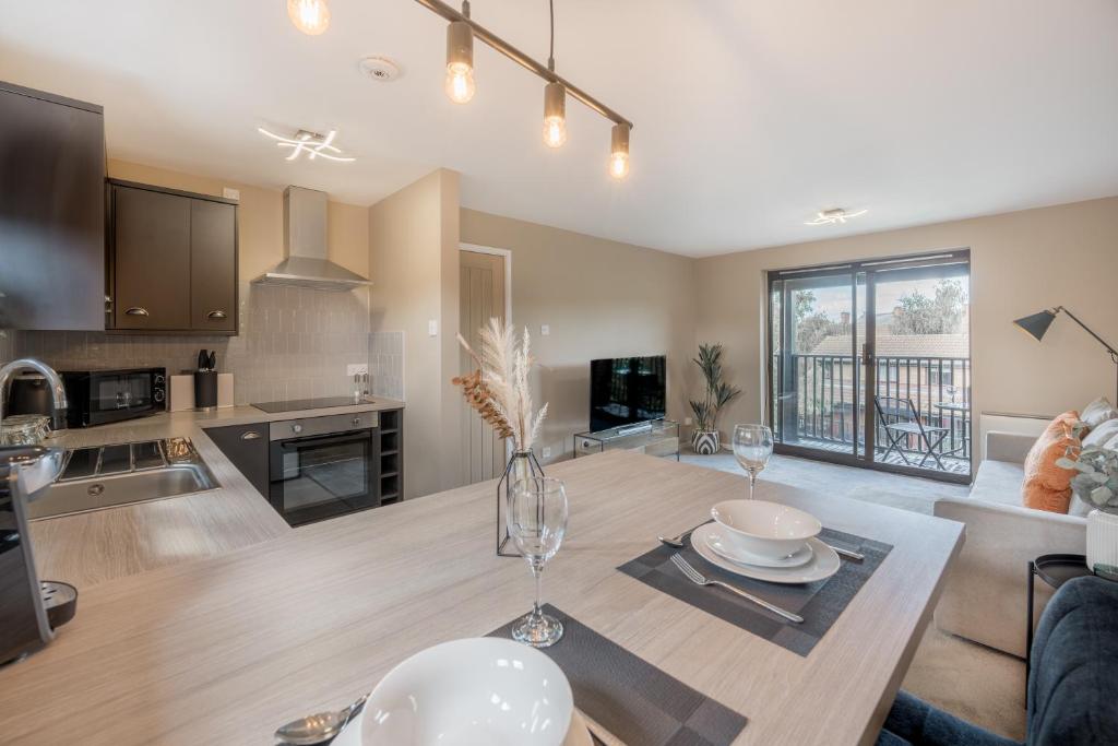 a kitchen and living room with a table and a dining room at Waterlily Apartment - Beautiful 1-bed with overlooking balcony in Nottingham