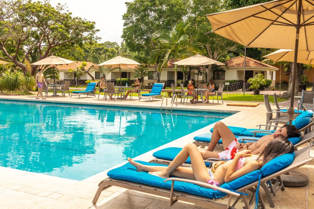 a group of people laying on rafts in a swimming pool at MAJU HOTEL CAMPESTRE & SPA in Jamapa