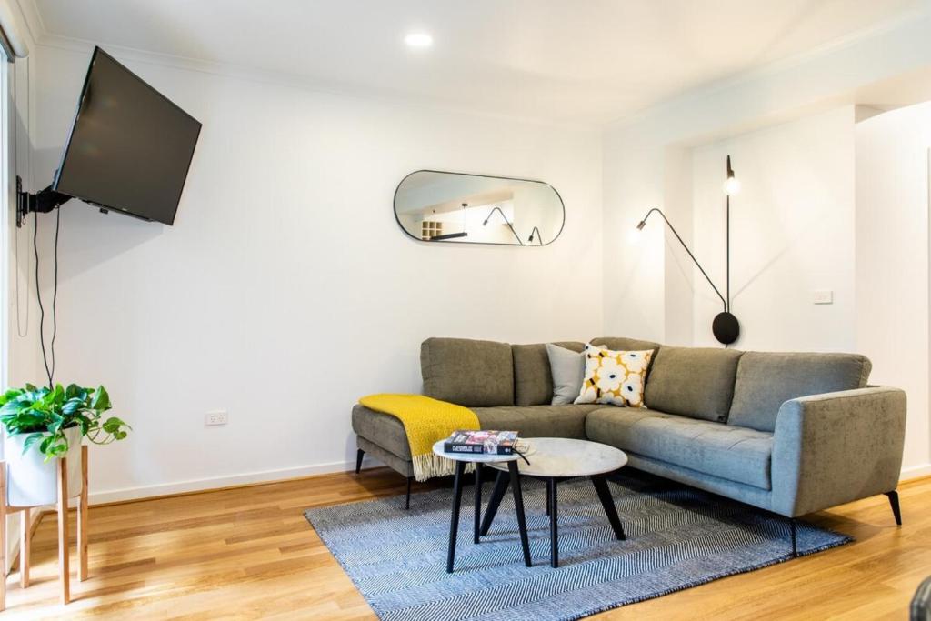 a living room with a couch and a table at Luxury spacious 2 Bedroom Fitzroy Apartment in Melbourne