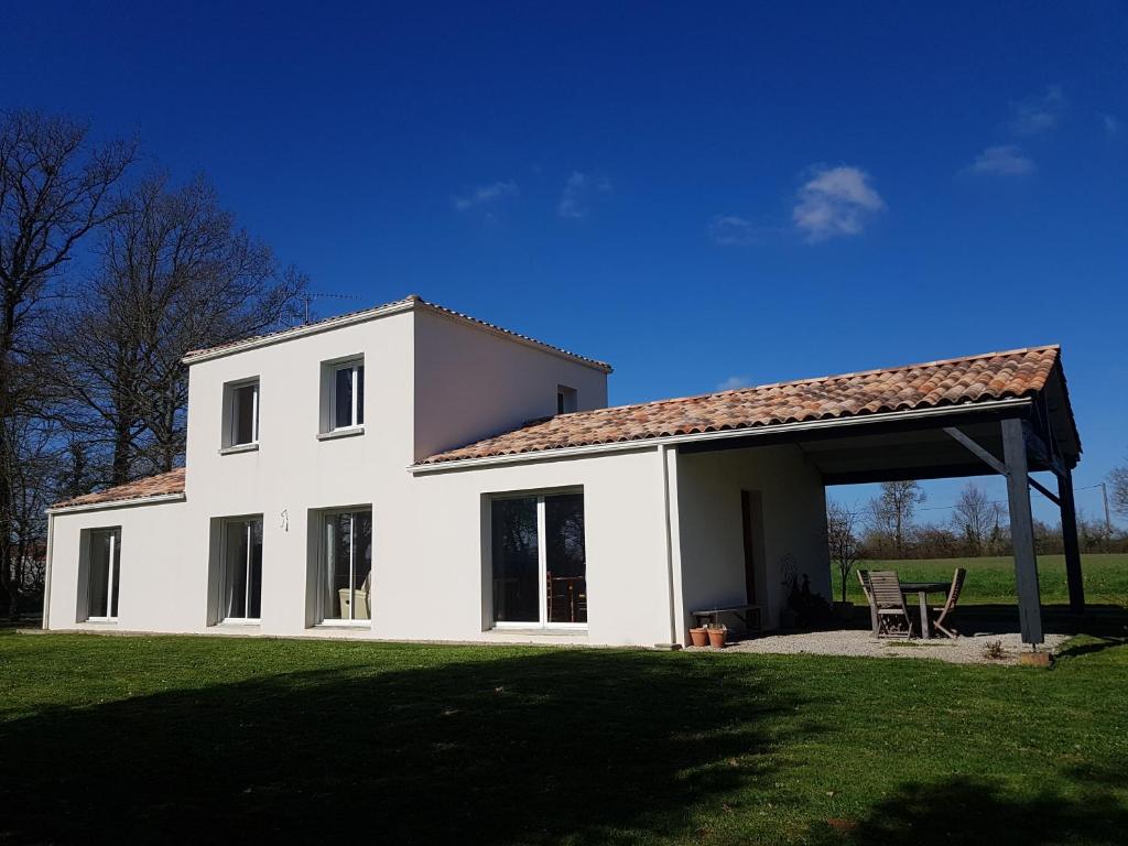 una casa bianca con un padiglione in un campo di Maison chaleureuse a Belleville-sur-Vie