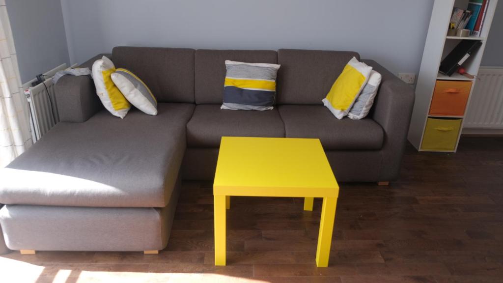 un soggiorno con divano e tavolo giallo di Spacious 1-bed flat in North Kensington a Londra