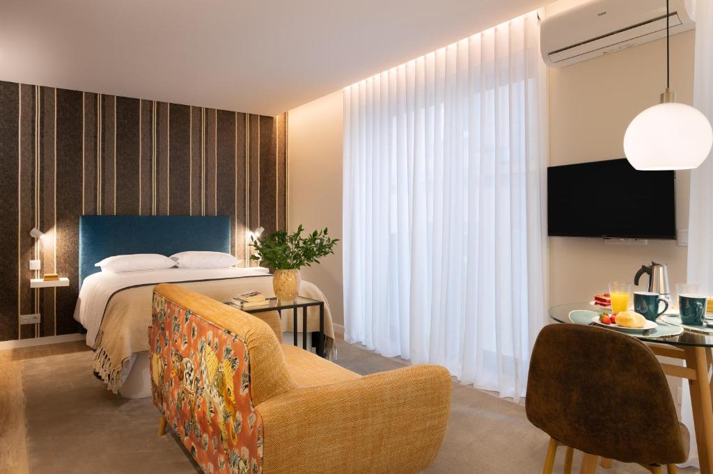 une chambre d'hôtel avec un lit et un canapé dans l'établissement Wanderlust, by Bolhão Residences, à Porto
