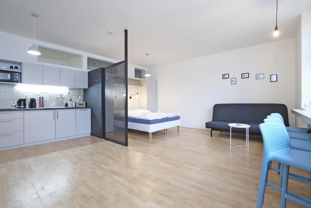 a kitchen and a living room with a couch and a table at City Hall view Apartment Liberec in Liberec