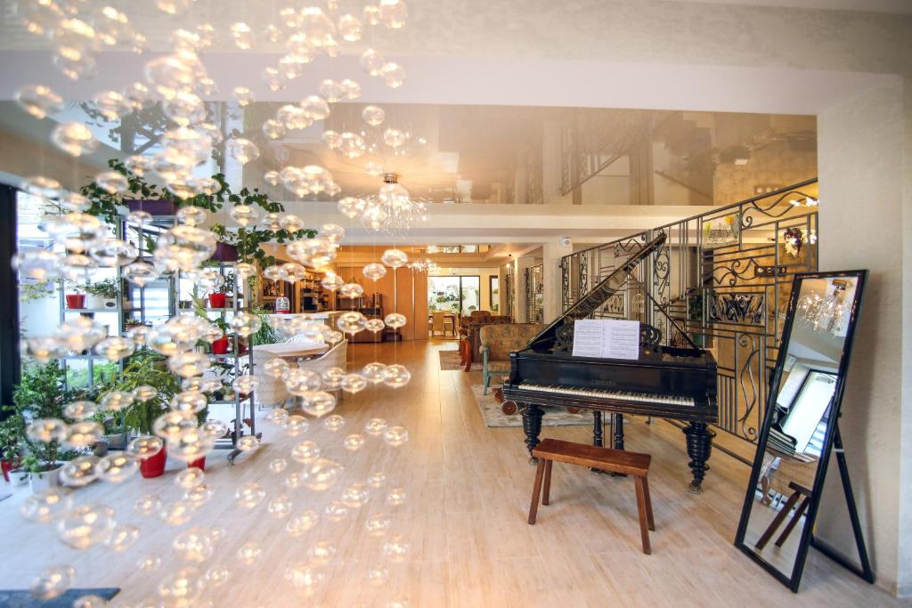 トビリシにあるHotel Keraのピアノとクリスマスツリーのあるリビングルーム