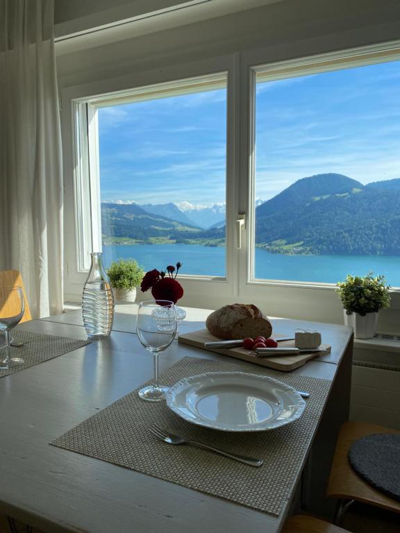 a table with a plate on a table with a window at Beautiful apartment with fantastic views in Oberägeri