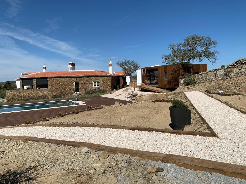 uma casa com uma piscina em frente em Monte Clérigo Casas de Campo em Almodôvar