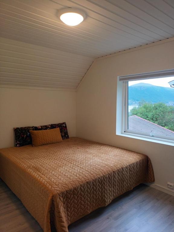 a bedroom with a bed and a window at Olgas apartment in Tromsø