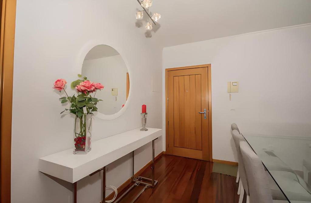 a bathroom with a sink with a vase of flowers at Praia Mar (sea view) by STAY Madeira Island in Ponta do Sol