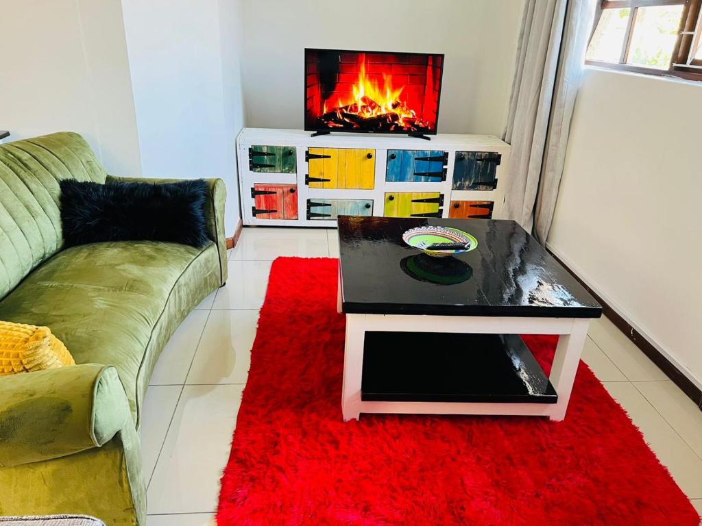 a living room with a couch and a fireplace at Safi Neat & Cozy Suite in East London