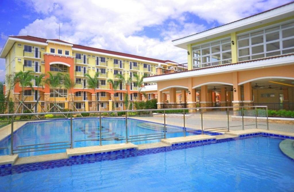 une grande piscine en face d'un bâtiment dans l'établissement Minimalist 1-bedroom condo unit CASA TIMMY, à Davao