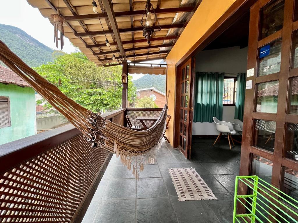 a hammock on the balcony of a house at Hostel Papagaio in Abraão