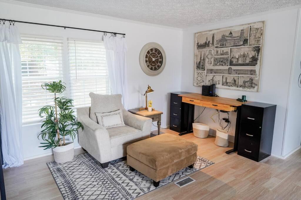ein Wohnzimmer mit einem Stuhl und einem Schreibtisch in der Unterkunft Beautiful Stylish 3 bedroom home in Greenville in Greenville