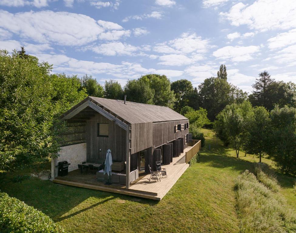 Casa de madera grande con terraza en un campo en The wood house/La Maison Bois, en Montembœuf