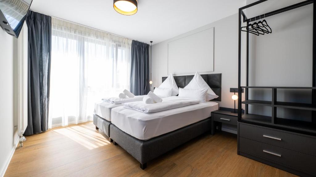 a bedroom with two beds and a large window at Hotel Metropol in Tübingen