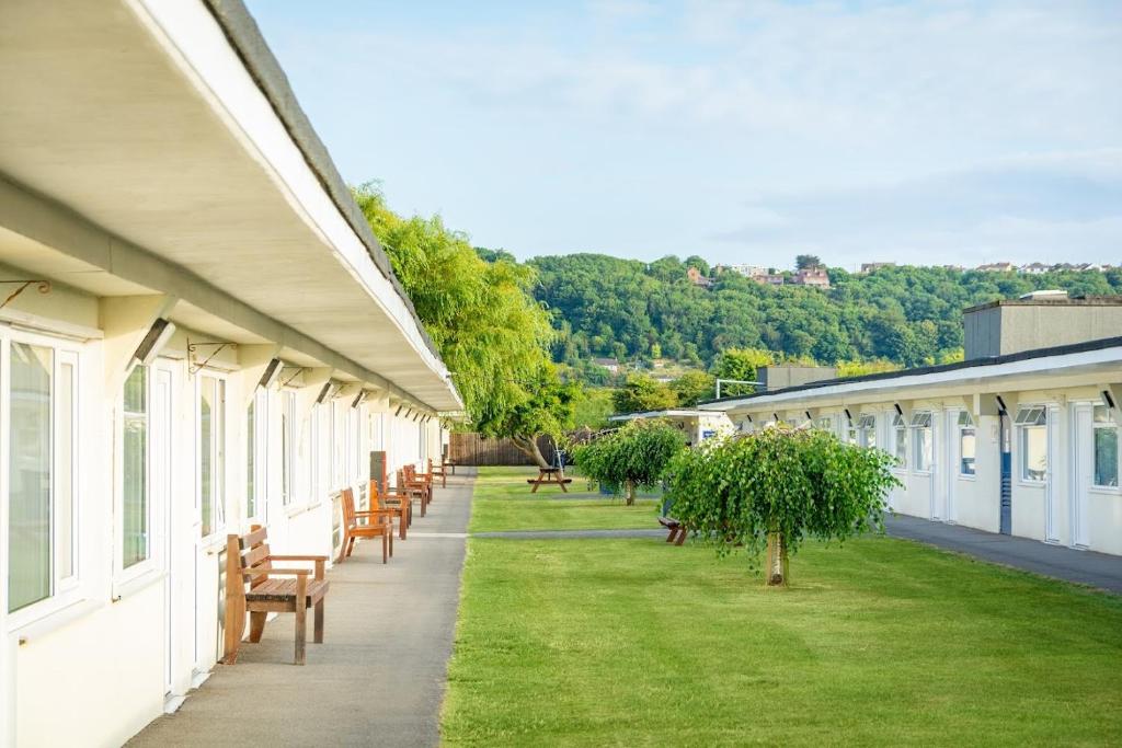 une rangée de bancs sur le côté d'un bâtiment dans l'établissement Sand Bay Holiday Village - Adults Only, à Weston-super-Mare