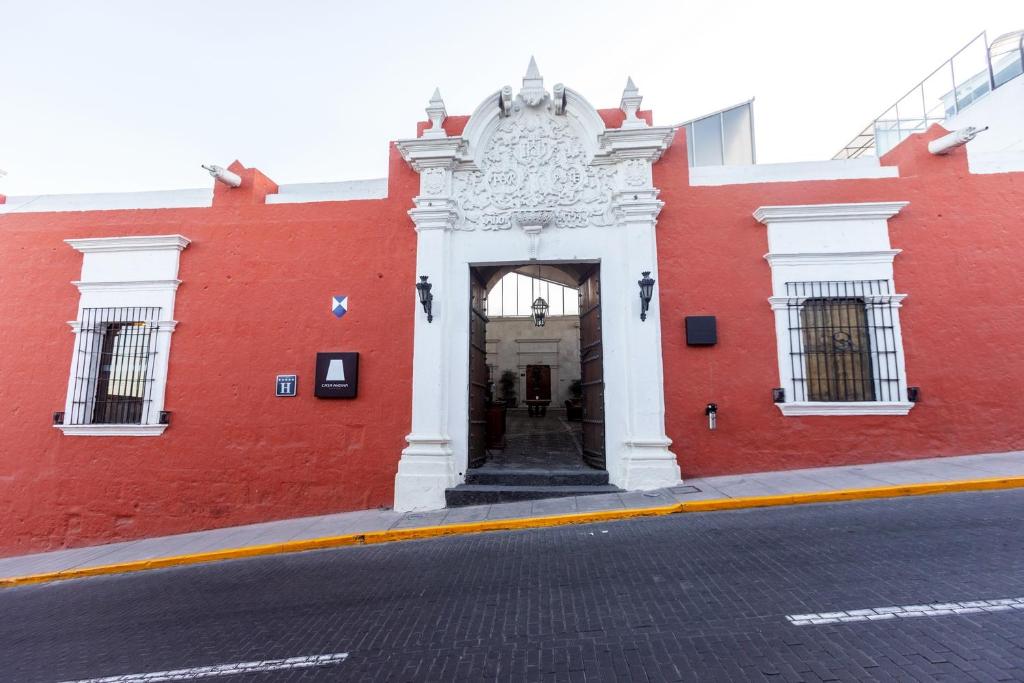 ein rotes Gebäude mit weißem Eingang in einer Straße in der Unterkunft Casa Andina Premium Arequipa in Arequipa