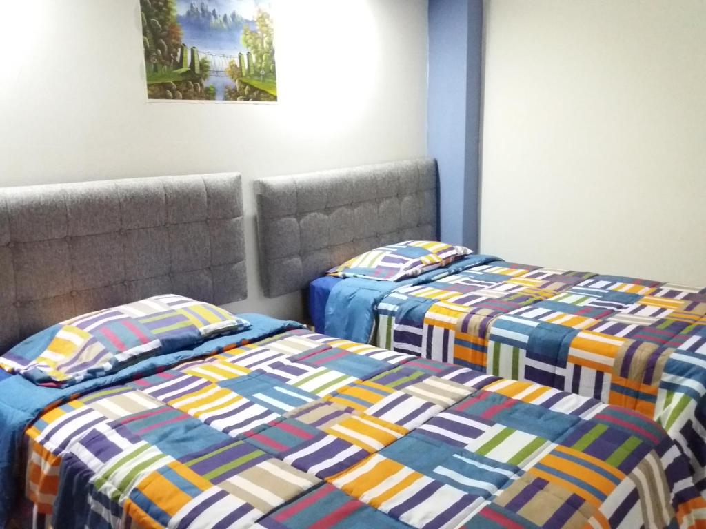 Duas camas sentadas uma ao lado da outra num quarto em Amaris Hotel em Ica