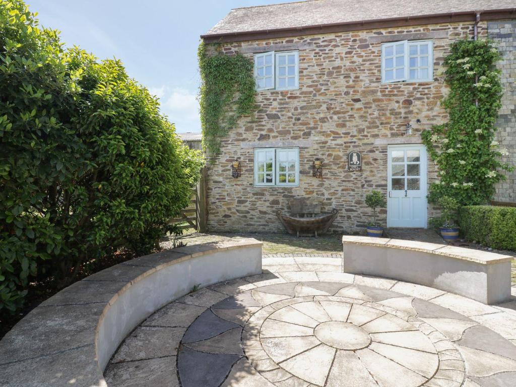 a brick house with a stone pathway in front of it at Owls Roost in Saint Goran