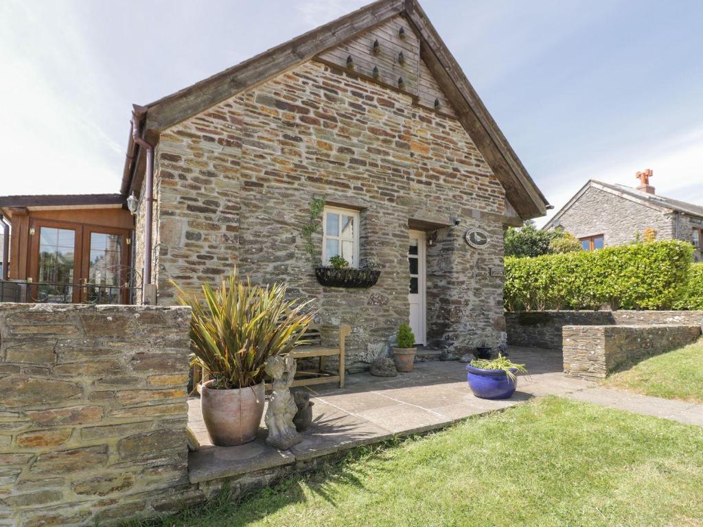 a stone house with a bench in the yard at Dovecote in Saint Goran