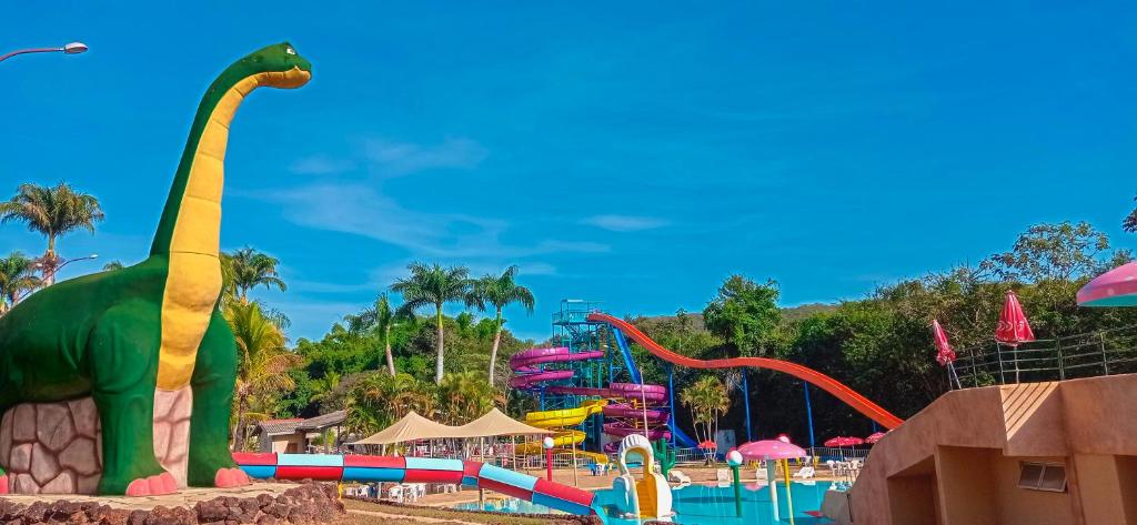 un parc aquatique avec un dinosaure au premier plan dans l'établissement Caldas Park & Hotel Caldas Novas, à Caldas Novas