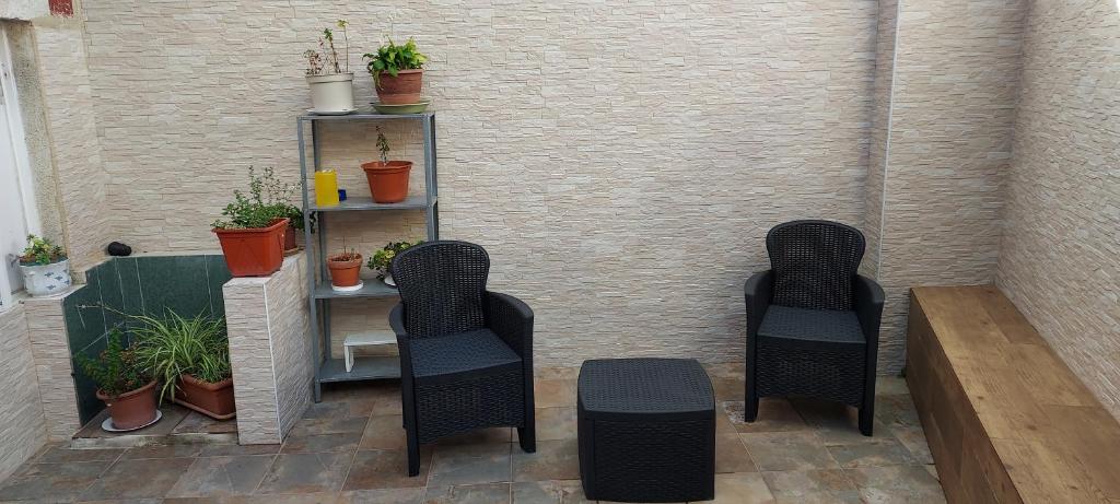 un patio con 2 sillas y un estante con plantas en BAYAMO, en Vigo