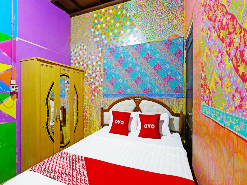 1 dormitorio con 1 cama y una pared colorida en OYO 91601 Double-Degree Syariah (Female & Family) en Sleman