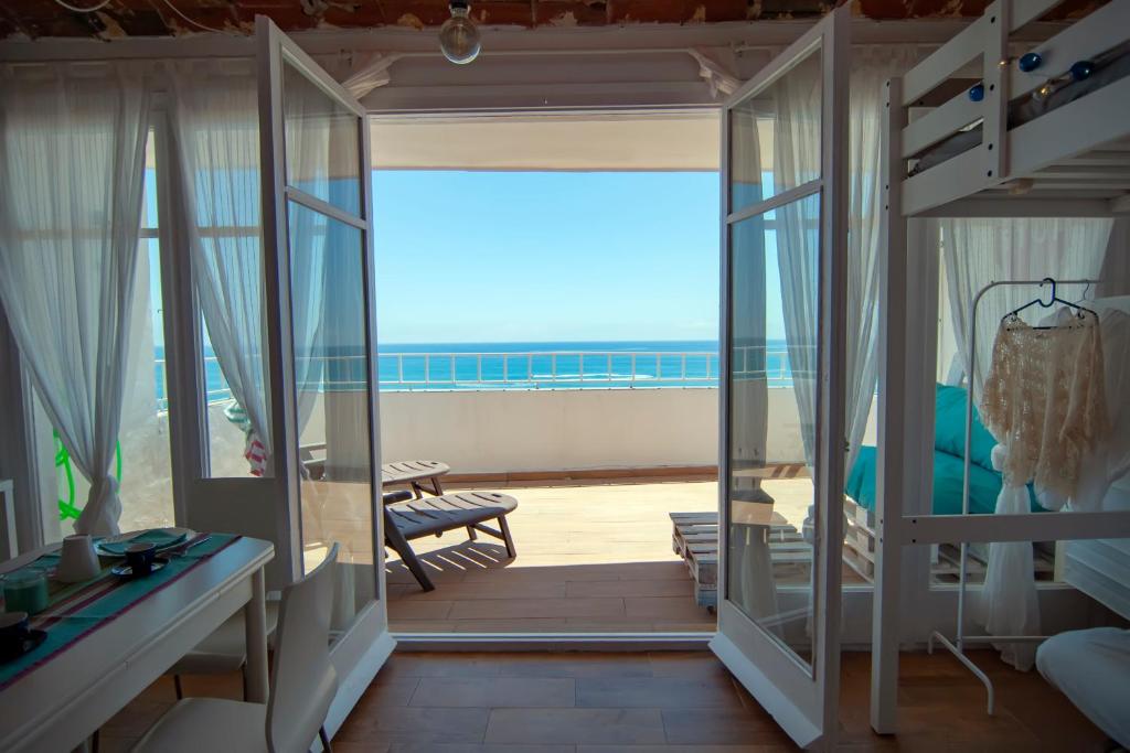 a room with a balcony with a view of the ocean at LOFT CANET DE MAR CERCA de BARCELONA in Canet de Mar