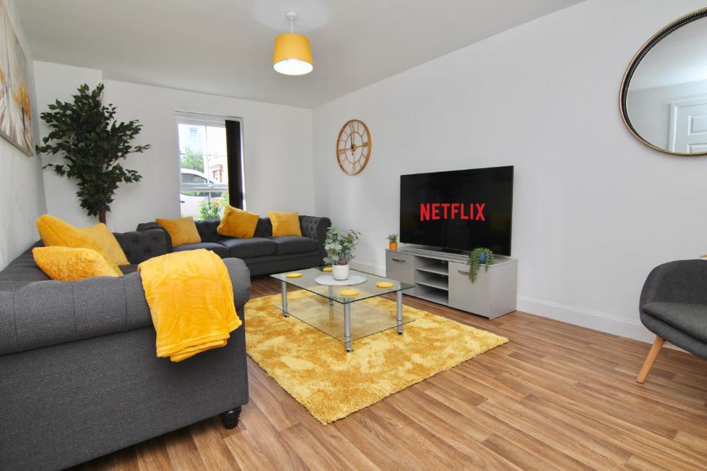 a living room with a couch and a tv at Serene 7Bed Escape - Steps from Coventry City Center, Holiday Bliss! in Coventry