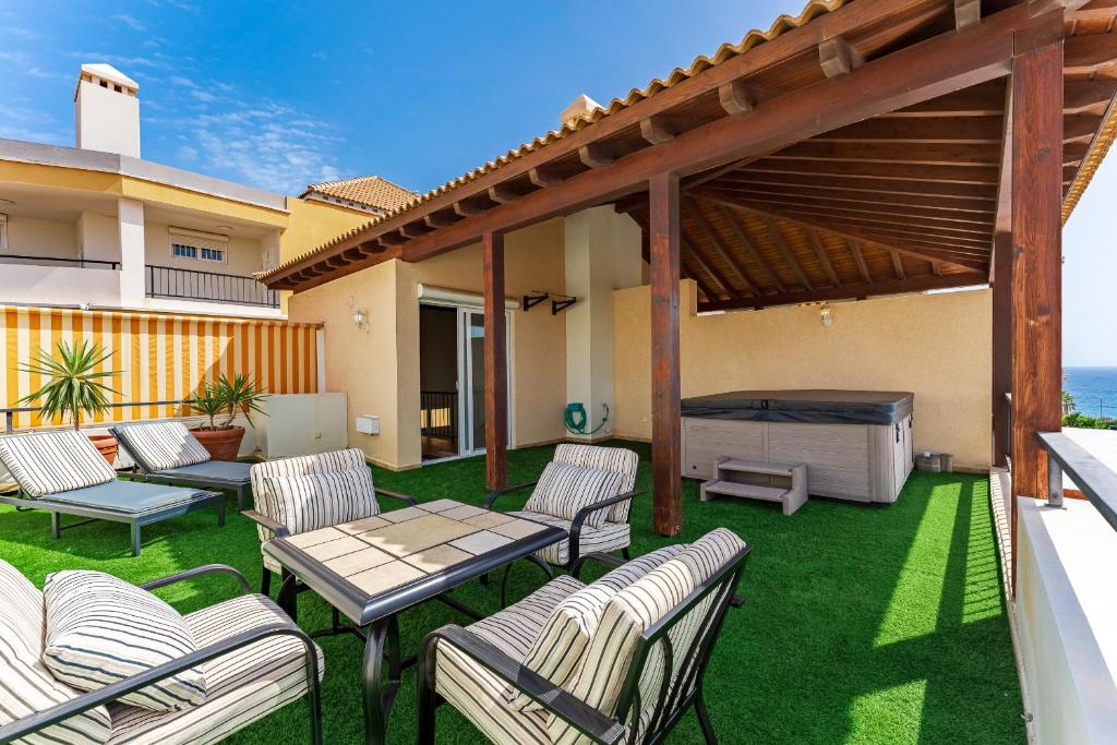 a patio with chairs and a table and a grill at Los Cristianos Duplex in Arona
