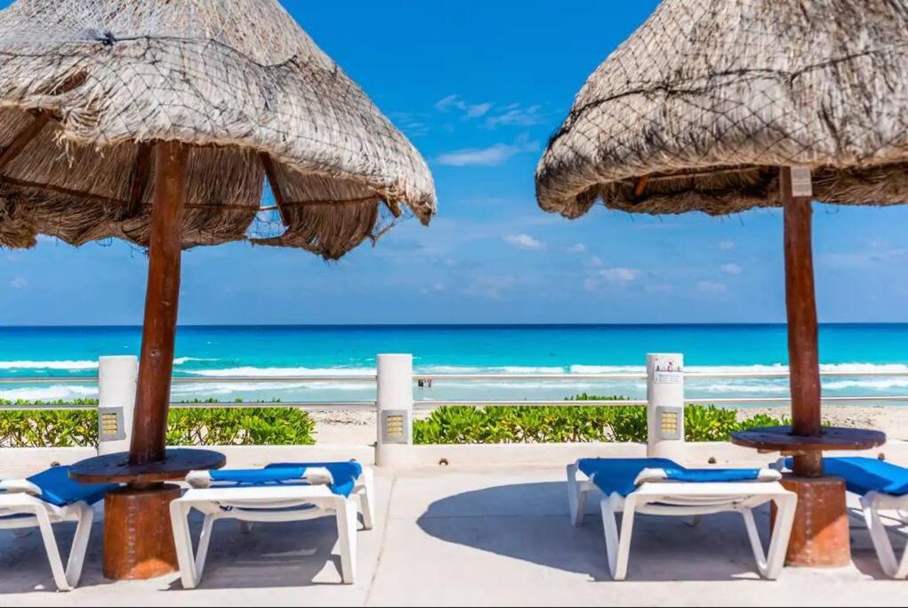 a group of chairs and umbrellas on the beach at Villas Marlin by Andiani Travel in Cancún