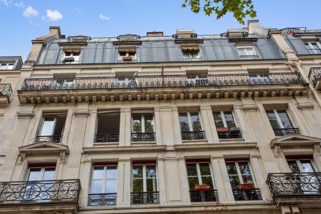 a building in paris with windows and balconies at Nice studio w balcony on Square Gardette in Paris - Welkeys in Paris