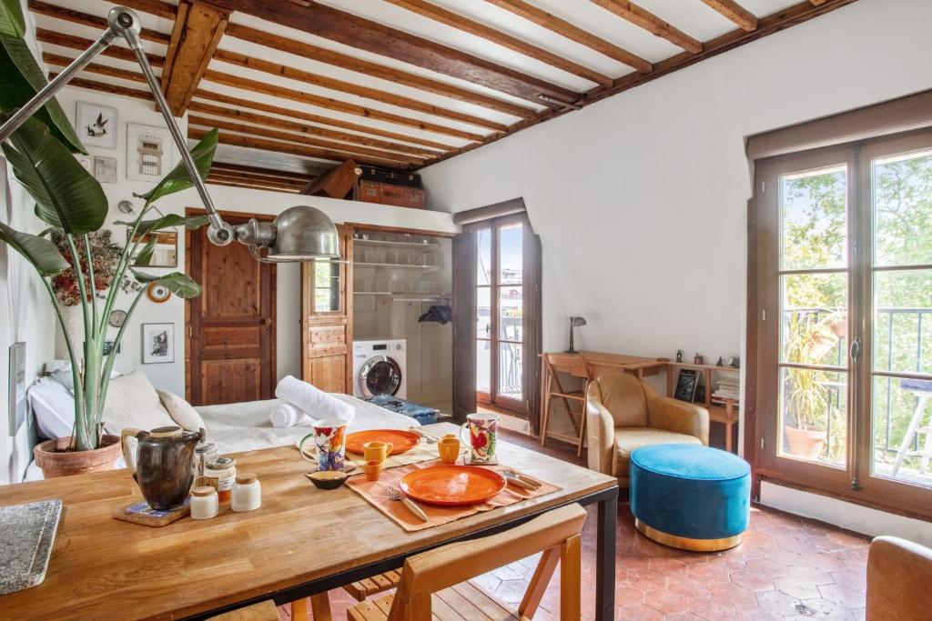 a living room with a wooden table in a room at Nice studio w balcony on Square Gardette in Paris - Welkeys in Paris