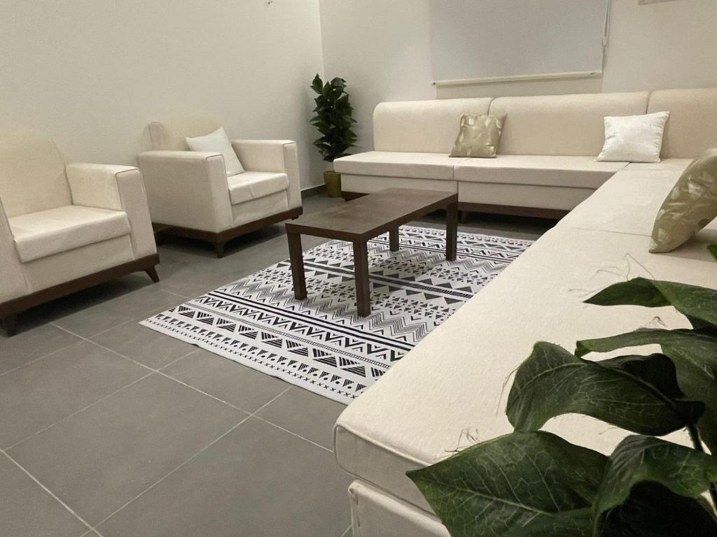 a living room with a couch and chairs and a table at LADAN APARTMENT in Al-ʿUla