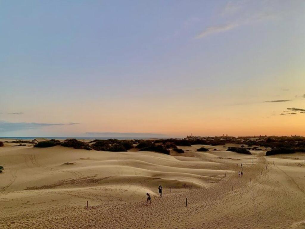 サン・バルトロメにあるLas Dunas de Maspalomas y el Mar a un pasoの砂漠の砂に立つ群衆