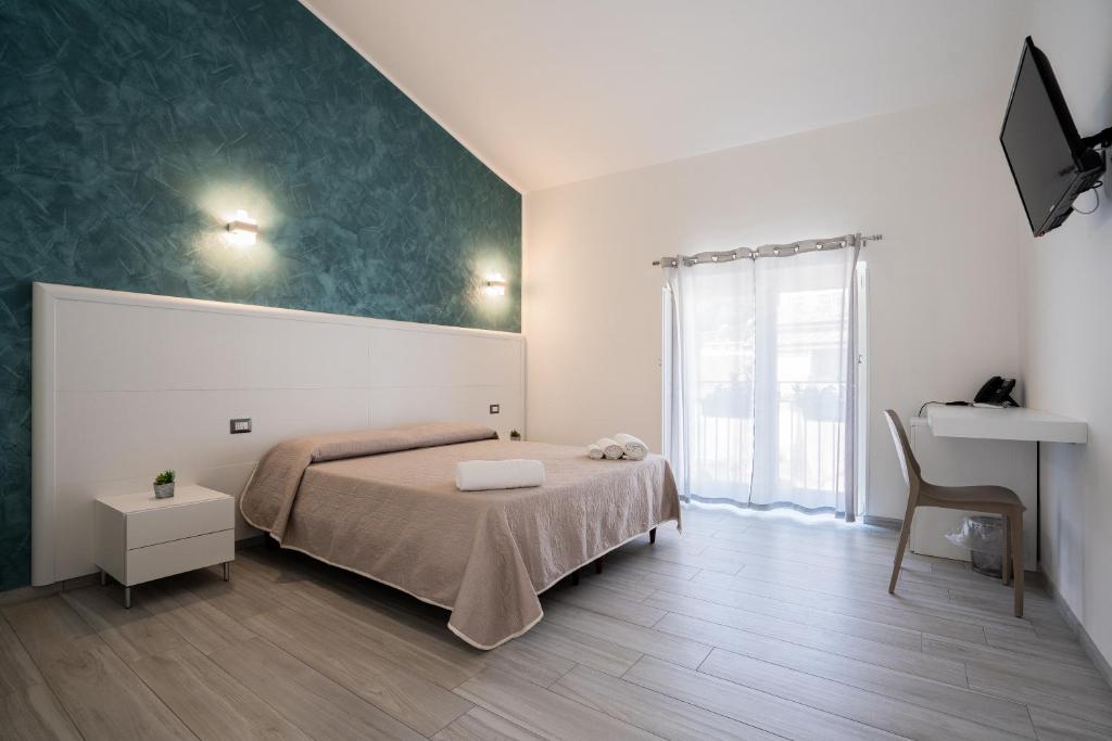 a bedroom with a bed and a table and a window at Harmonia Home Capitello in Capitello
